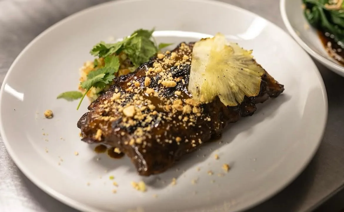 Costillas glaseadas con maní, ananá grillado y cilantro